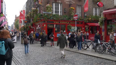 Barra-an-Teampaill---Tourists-Walking-In-The-Street-With-The-Temple-Bar-Pub-In-Dublin,-Ireland