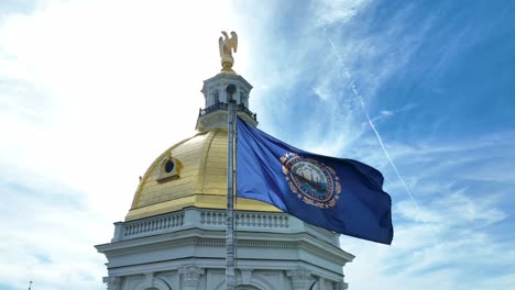 La-Bandera-Del-Estado-De-New-Hampshire-Ondea-Orgullosamente-Junto-Al-Edificio-Del-Capitolio-De-La-Casa-Estatal-En-Un-Día-Soleado