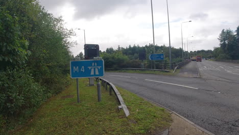 M4-Autobahnkreuzung-Schild-Mit-Autos,-Die-In-Die-Auffahrt-In-Der-Nähe-Von-Swansea-Uk-4k-Einfahren