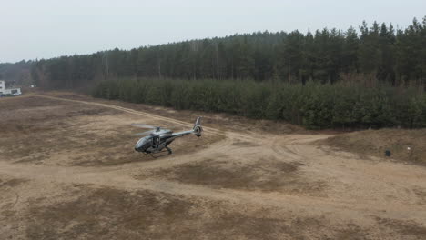 Aerial-View-of-Military-Helicopter-Flying-Above-Training-Field,-Drone-Shot