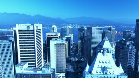 Vancouver-downtown-business-building-drone-closeup-flyover-Burrard-St-between-Georgia-and-Robson-on-sunny-day-stunning-mountains-North-Vancouver-Harbor-RBC-Fairmont-Hotel-Vancouver-4k-YVR2-4