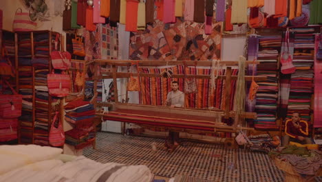 Junger-Mann-Webt-Textilien-In-Einem-Handwerklichen-Familiengeschäft-In-Fes,-Marokko
