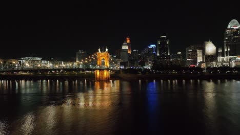 Aerial-view-low-over-the-river-with-the-illuminated-Cincinnati-skyline-in-the-background