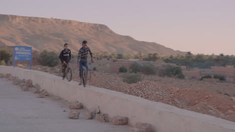 Toma-Dinámica-Y-Documental-De-Niños-Marroquíes-Pobres-Jugando-Con-Un-Neumático-Usado-En-Una-Pequeña-Pared-Al-Costado-De-La-Carretera