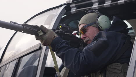 Special-Unit-Police-Office-in-Helicopter-Holding-Sniper-and-Pointing-to-Target,-Close-Up