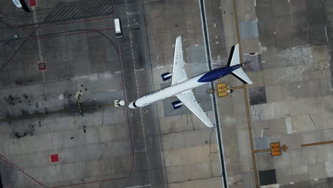 Aerial-view-of-a-tug-vehicle-pushing-an-airplane-at-the-aerodrome,-in-Mexico-city
