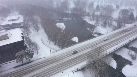 Aerial-view-of-cars-passing-over-a-bridge-in-the-snow