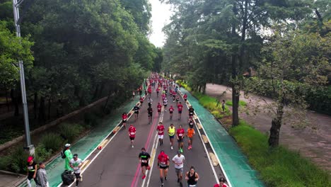 Aufwärtsdrohnenaufnahme-Der-Läufer-Des-Mexico-City-Marathons,-Die-In-Ihrem-Eigenen-Tempo-Durch-Die-Paseo-De-La-Reforma-Avenue-Laufen