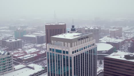 Aerial-shot-of-Zions-Banks-skyscraper-in-Boise,-Idaho-with-snow-covering-the-ground