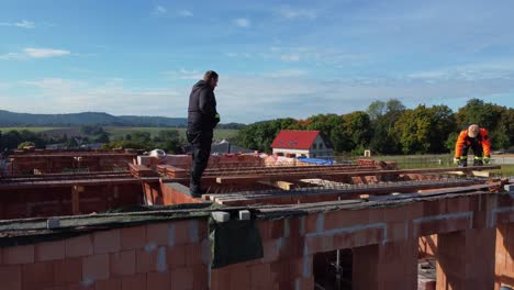 Bau-Eines-Neuen-Daches,-Luftdrohnenseite,-Nahaufnahme-Von-Arbeitern,-Sonniger-Tag