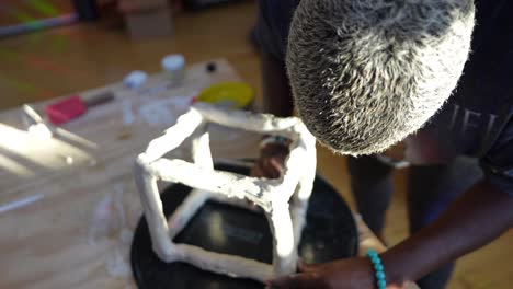 4k-60fps---An-african-american-artist-sculpting-a-clay-box-in-her-studio-during-golden-hour