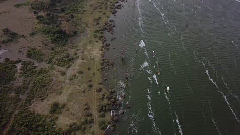 Group-of-three-boats-sailing-single-file-near-the-shore-of-Lake-Naivasha,-located-in-Kenya,-Africa