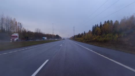 POV-shot-of-a-car-driving-along-the-wet-roads-with-cars-passing-in-Helsinki