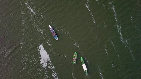 Zoom-in-aerial-view-of-two-green-and-one-blue-boat-sailing-on-Lake-Naivasha,-Kenya