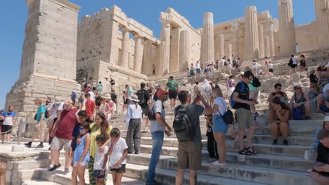 Toma-Panorámica-De-La-Monumental-Puerta-De-Entrada-De-Los-Propileos,-Escalera-Abarrotada-De-Turistas,-Grecia