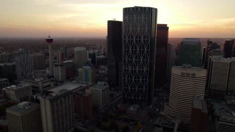 Aerial-view-approaching-the-silhouette-the-bow-building-in-Calgary-city,-sunset-in-Alberta,-Canada