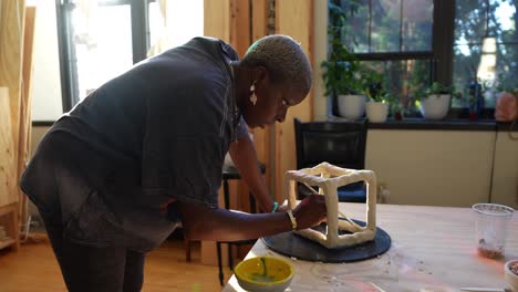 4k-60fps---An-african-american-artist-sculpting-a-box-in-her-studio-during-golden-hour