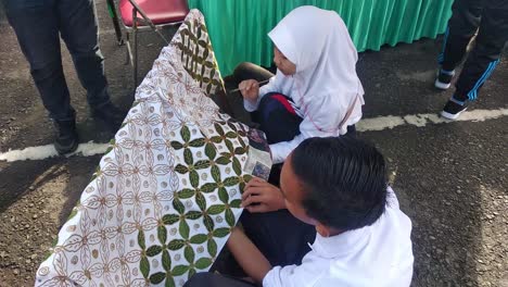 Zwei-Studenten-üben-Das-Schreiben-Von-Umweltfreundlichen-Batikmotiven