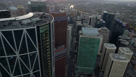 Aerial-view-over-the-5th-avenue,-passing-the-Bow-building,-sunset-in-Calgary,-Canada