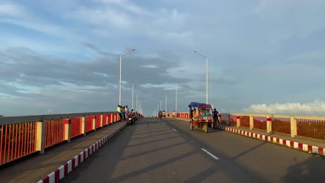 FPV-of-motorbike-riding-on-bridge-in-Bangladesh-city-with-many-motorcycles,-day