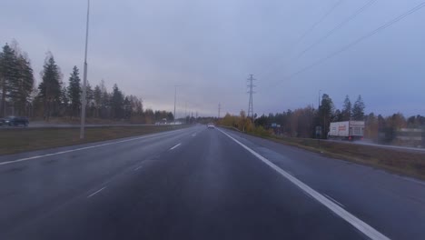 POV-shot-traveling-along-the-wet-highway-with-few-cars-on-the-road