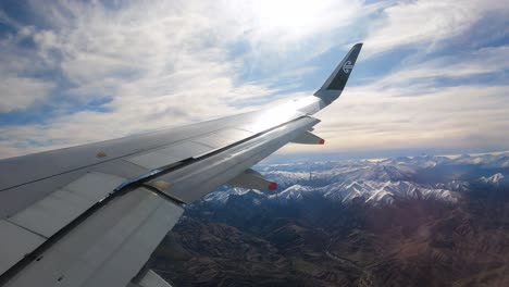 View-Of-An-Aircraft-Wing-Flaps-Flying-Over-Snowy-Mountains-In-New-Zealand-On-A-Sunny-Day