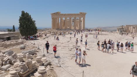 Crowded-Acropolis-of-Athens-on-Sunny-day-with-Parthenon-temple-in-Background,-Tilt-up-shot