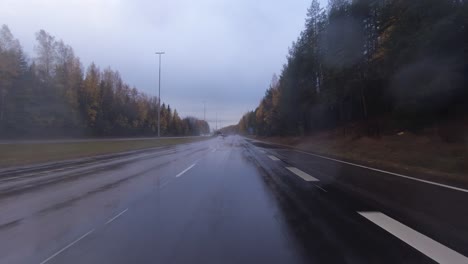 Traveling-along-the-motorway-and-going-under-a-bridge-on-a-wet-road