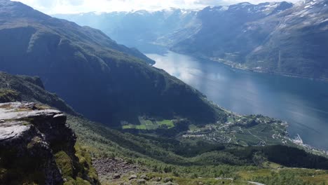 Friends-having-lunch-break-together-at-viewpoint-along-Dronningstien-queens-hiking-path-between-Kinsarvik-and-Lofthus-in-Hardanger-Norway---Aerial-passing-persons-and-revealing-stunning-view