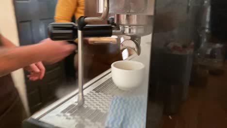 Barista-pulls-an-espresso-from-a-Wega-coffee-machine-before-serving-a-croissant-in-Boston-Coffee-shop-in-Bellville,-South-Africa