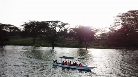 Aerial-view-of-a-boat-with-a-group-of-people-sailing-on-Lake-Naivasha,-Kenya