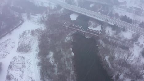 Aerial-shot-of-a-train-track-bridge-crossing-the-Boise-River-during-a-blizzard