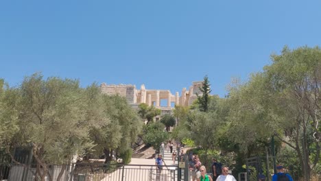 Touristen,-Die-Die-Stufen-Vom-Besuch-Der-Akropolis-Hinuntergehen-Und-Am-Eingangstor-Vorbeigehen