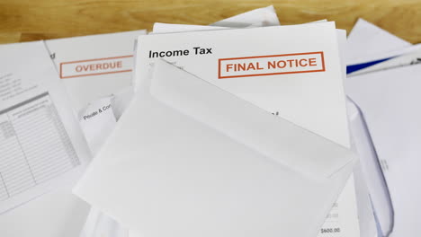 A-stack-of-bills-and-debts-with-an-income-tax-final-notice-letter