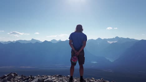 Hiker-watching-Rocky-Mountain-range-forests-and-lakes-Close-Up-Kananaskis-British-Columbia-Canada