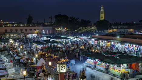 View-over-busy-Jemaa-el-fna-central-square-in-Marrakesh-from-blue-hour-into-the-night,-4k-timelapse