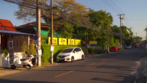 Calle-Típica-De-Barrio-En-Chiang-Mai,-Tailandia-Con-Tráfico-Durante-La-Puesta-De-Sol