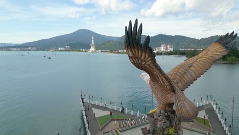 Aerial-shot,-Dataran-Lang-Statue-or-Langkawi-Eagle-Statue-with-sea-and-mountain