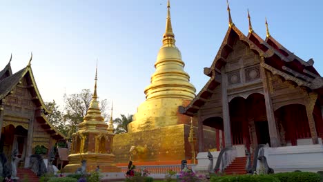 Slow-pan-across-temple-with-golden-Pagoda-and-tourists-in-Chiang-Mai,-Thailand