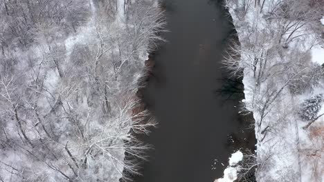 Blick-Von-Oben-Auf-Einen-Fluss-Mit-Schnee,-Der-Die-Ufer-Bedeckt