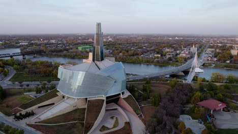 Aerial-view-around-the-Canadian-Museum-for-Human-Rights,-sunrise-in-Winnipeg,-Canada---orbit,-drone-shot