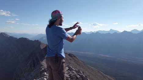 Hiker-opening-beer-on-peak-at-Rocky-Mountain-range-Kananaskis-Alberta-British-Columbia-border-Canada