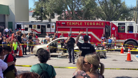 Static-handheld-shot-of-a-Police-Officer-talking-to-a-crowd-at-a-demonstration-for-kids-at-an-Annual-Fire-Department-Open-House-event-organized-by-Temple-Terrace,-Florida