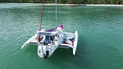 Aerial-drone-shot-of-messy-trimaran-boat-with-solar-panel-floating-on-the-sea