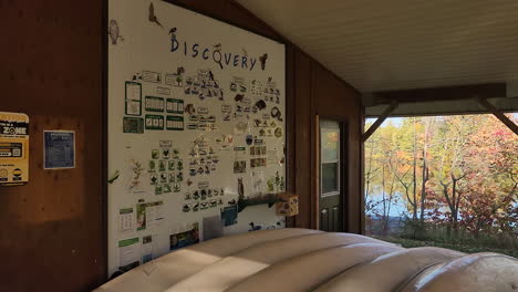 A-decorative-information-board-for-birdwatchers-to-identify-different-species-of-local-birds-on-the-wall-of-a-park-hide,-Canada