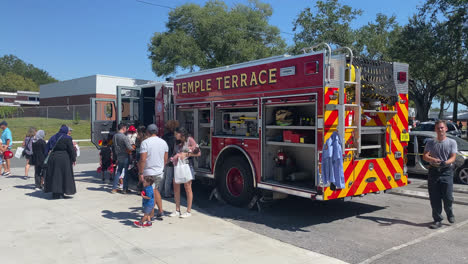 Öffentliche-Präsentationsveranstaltung-Mit-Feuerwehrfahrzeug-In-Der-Feuerwache-Temple-Terrace,-Florida,-Besucher,-Die-Praktische-Erfahrungen-Mit-Der-Ausrüstung-Des-Feuerwehrfahrzeugs-Sammeln