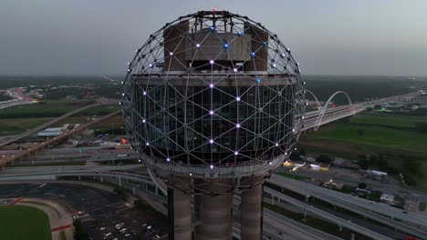 Reunion-Tower-Plaza-orbit-at-night-with-lights-and-traffic-on-freeway-in-Dallas-Texas