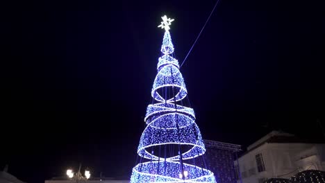 Zeitlupe-Aufsteigender-Dolly-schuss-Eines-Leuchtenden-Kegels,-Der-Mit-Einem-Leuchtenden-Stern-An-Der-Spitze-Dekoriert-Ist,-Für-Weihnachten-Nachts-In-Einem-Blau-weißen-Licht-In-Medina-Sidonia-In-Spanien