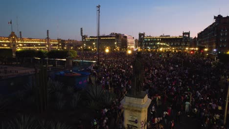 Zocalo-Square-full-of-people,-violent-protests,-dusk-in-Mexico-city---Aerial-view