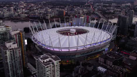 Aerial-view-in-front-of-the-illuminated-BC-Place-Stadium,-dusk-in-Vancouver,-Canada---rising,-tilt,-drone-shot